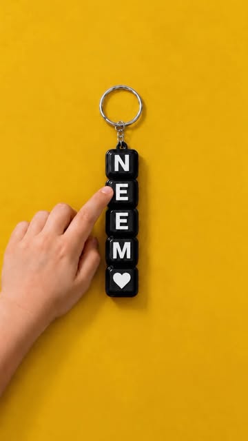 Black tactile keychain against a bright yellow background